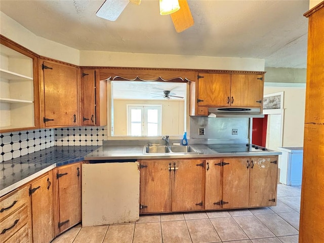 kitchen with light tile patterned flooring, backsplash, sink, ceiling fan, and stovetop