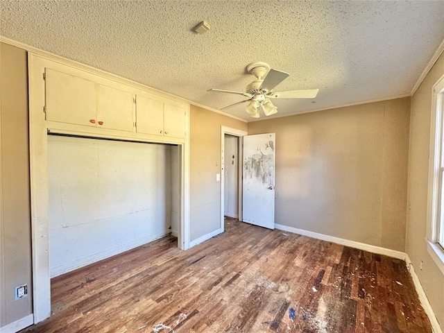 unfurnished bedroom with crown molding, ceiling fan, a closet, and wood-type flooring