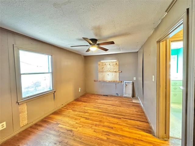 unfurnished room featuring a textured ceiling, light hardwood / wood-style flooring, and ceiling fan