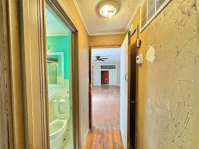 hall with hardwood / wood-style flooring and ornamental molding