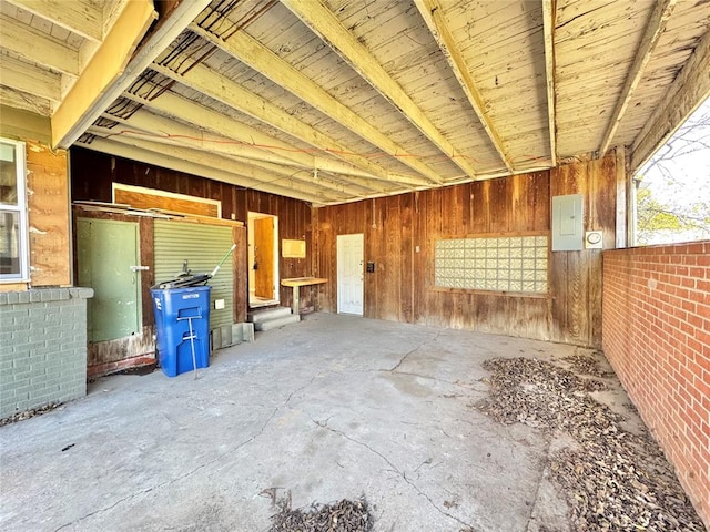 miscellaneous room featuring electric panel and wood walls