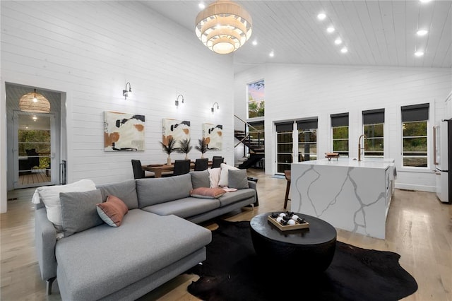 living room with a wealth of natural light, light wood-type flooring, and high vaulted ceiling