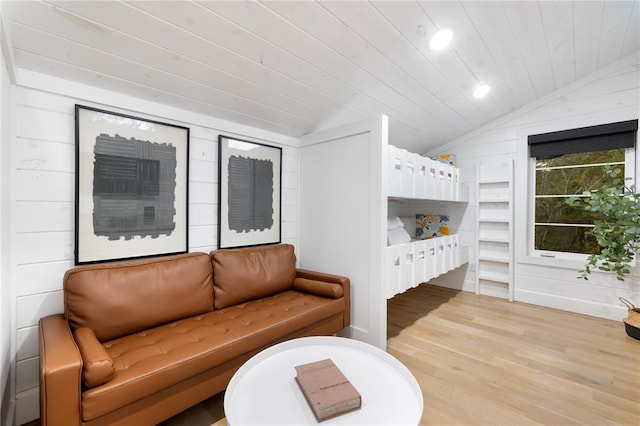 bedroom with wooden walls, light wood-type flooring, lofted ceiling, and wood ceiling