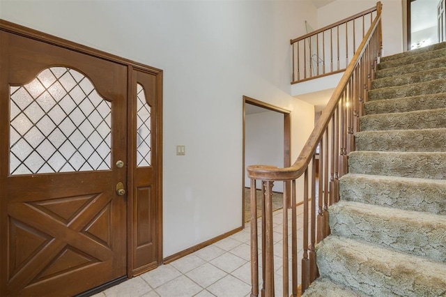 tiled foyer featuring a towering ceiling and a healthy amount of sunlight