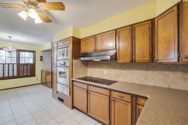 kitchen with pendant lighting, backsplash, ceiling fan with notable chandelier, light tile patterned floors, and appliances with stainless steel finishes