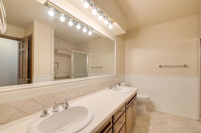 bathroom with tile patterned floors, vanity, toilet, and walk in shower