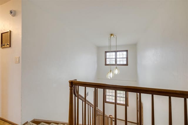 stairs with a chandelier