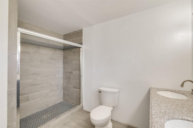 bathroom featuring vanity, toilet, and a shower with shower door