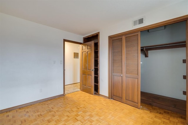 unfurnished bedroom with a closet and light parquet floors