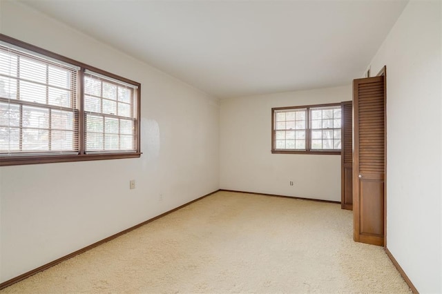 spare room featuring light colored carpet