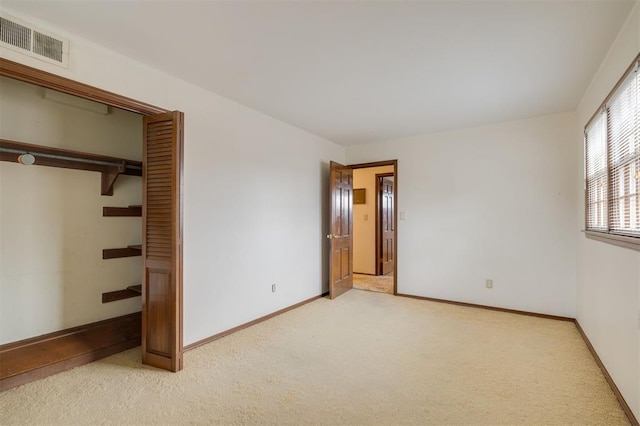 unfurnished bedroom with light carpet and a closet