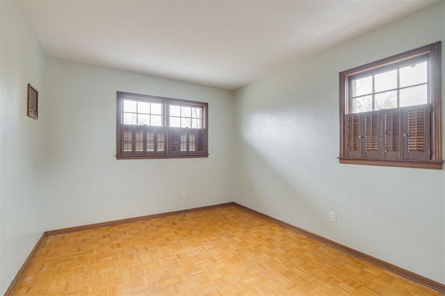 empty room with light parquet flooring and a wealth of natural light