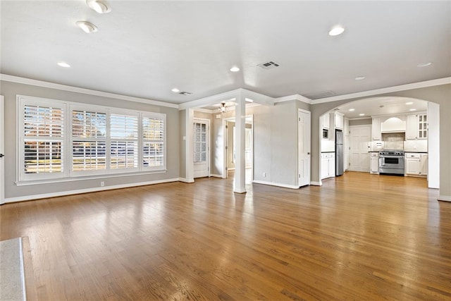 unfurnished living room featuring hardwood / wood-style floors, ceiling fan, and ornamental molding