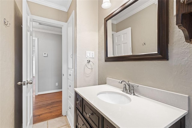 bathroom with hardwood / wood-style flooring, vanity, and crown molding