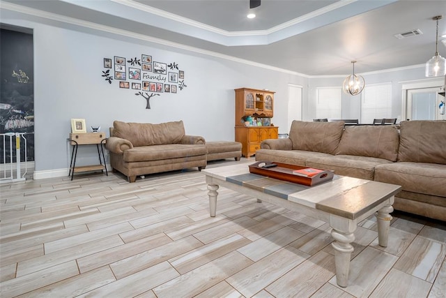 living room featuring crown molding, light hardwood / wood-style flooring, and a notable chandelier