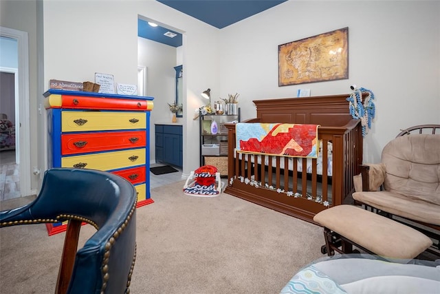 carpeted bedroom with ensuite bathroom and a crib