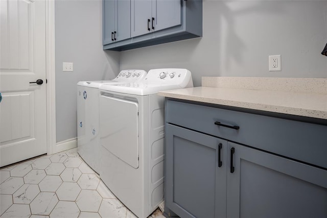 laundry area with separate washer and dryer and cabinets