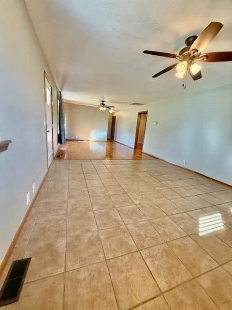 unfurnished room with ceiling fan and light tile patterned floors