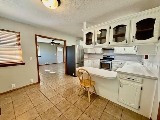 kitchen with white cabinetry, ceiling fan, stainless steel appliances, and light tile patterned floors