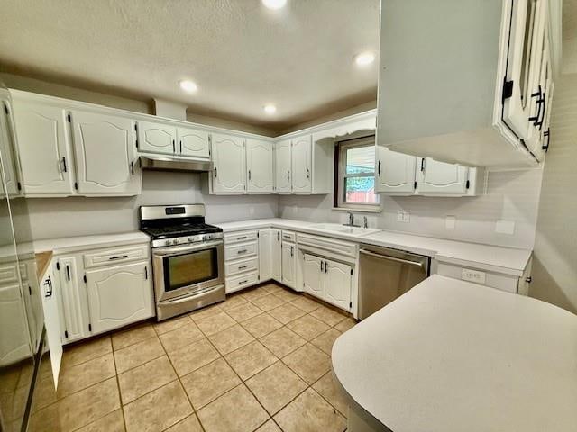 kitchen with white cabinets, light tile patterned floors, sink, and appliances with stainless steel finishes