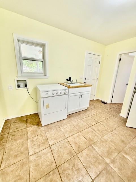 washroom featuring light tile patterned flooring, cabinets, sink, and washer / clothes dryer