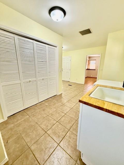 interior space featuring light tile patterned floors, sink, and wooden counters