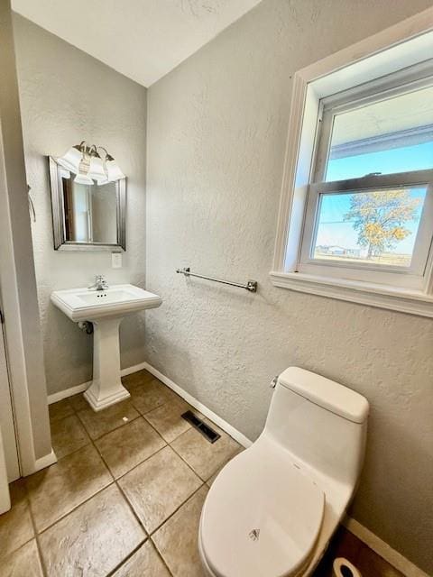 bathroom featuring tile patterned flooring, toilet, and sink