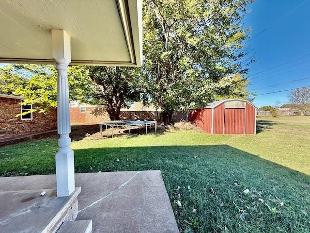 view of yard featuring a storage unit, a patio, and a trampoline