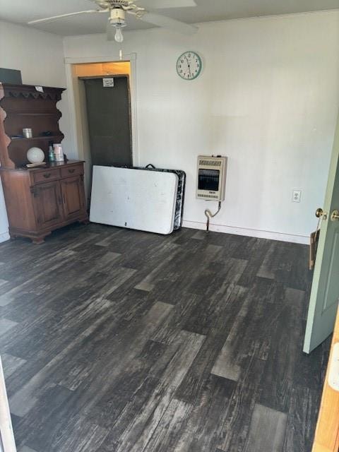 interior space with ceiling fan, dark hardwood / wood-style flooring, and heating unit