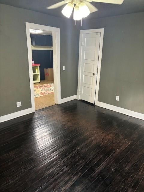 unfurnished room featuring ceiling fan and dark wood-type flooring