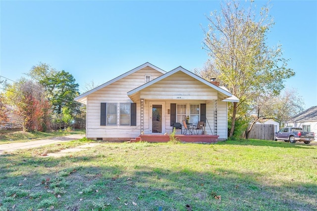 bungalow-style house featuring covered porch and a front yard