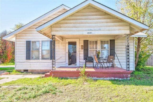 view of front facade featuring covered porch and a front yard