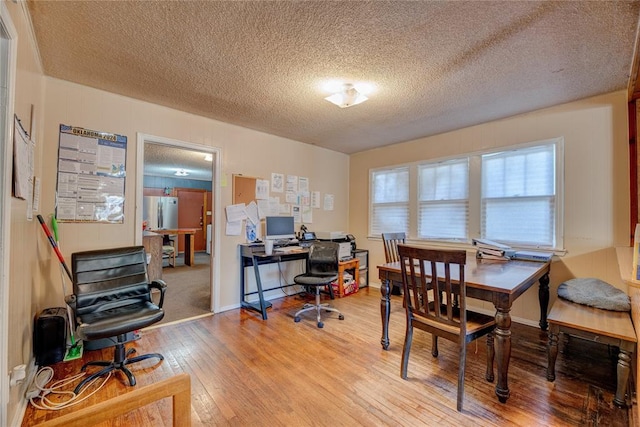 office space featuring a textured ceiling and light hardwood / wood-style floors