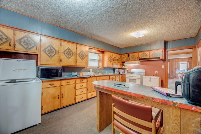 kitchen featuring a textured ceiling, white range with gas stovetop, light carpet, and washer / clothes dryer