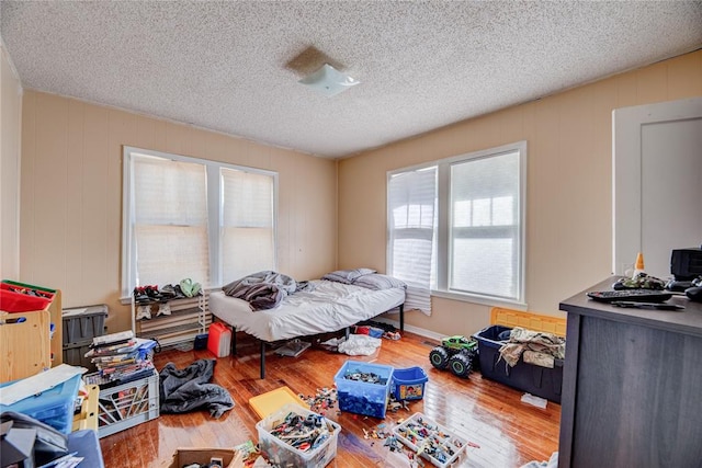 bedroom featuring wood-type flooring and a textured ceiling