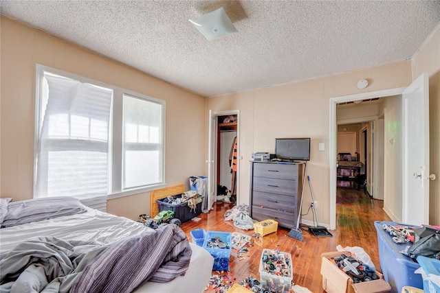 bedroom featuring wood-type flooring, a textured ceiling, and a closet