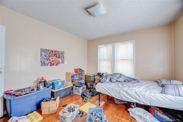 bedroom with hardwood / wood-style flooring and a textured ceiling