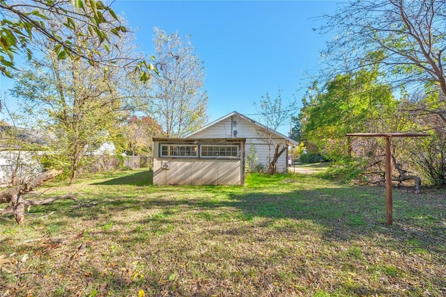 back of property with a yard and a storage shed