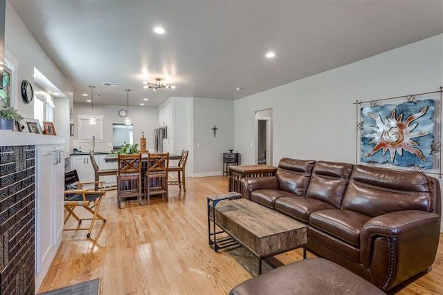 living room featuring sink and light hardwood / wood-style floors