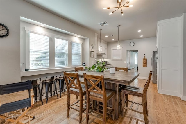 dining room with a chandelier and light hardwood / wood-style flooring