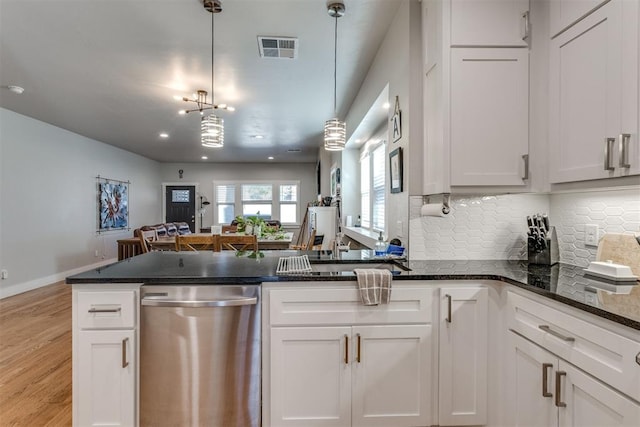 kitchen featuring white cabinetry, hanging light fixtures, stainless steel dishwasher, and light wood-type flooring