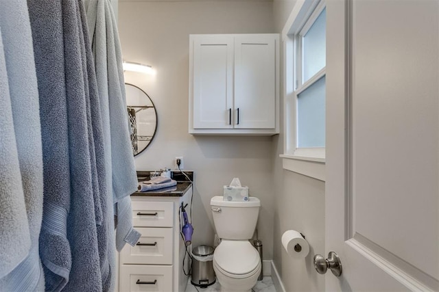 bathroom with vanity, a healthy amount of sunlight, and toilet