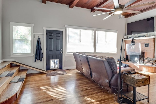 living room with hardwood / wood-style floors, ceiling fan, wood ceiling, and a brick fireplace