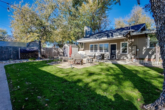 rear view of house with a yard and a patio