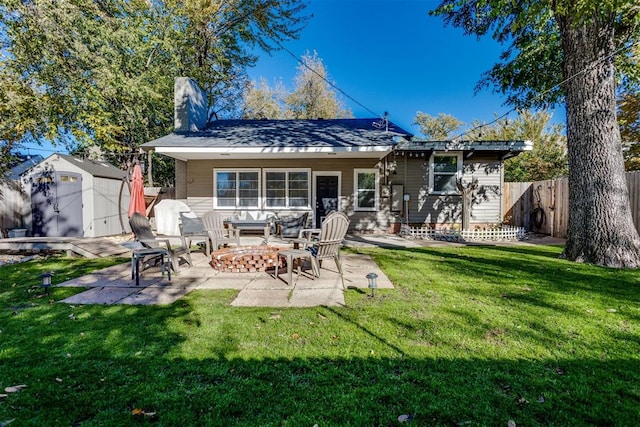 back of property with a storage unit, a patio, an outdoor fire pit, and a lawn