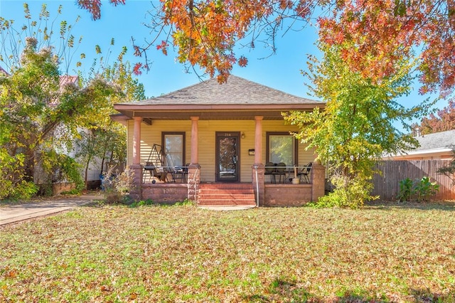 bungalow featuring a porch and a front lawn