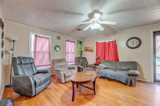 living room with hardwood / wood-style floors, a textured ceiling, ceiling fan, and crown molding