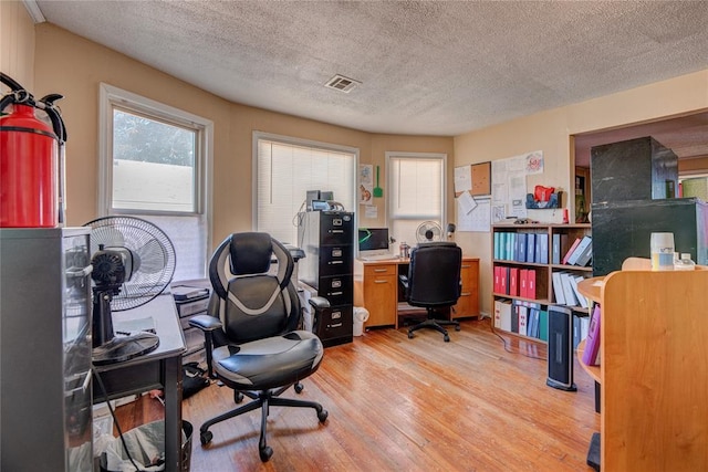 office featuring light hardwood / wood-style flooring and a textured ceiling