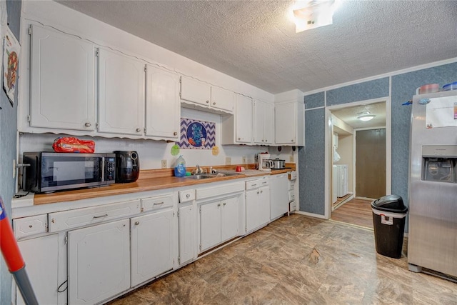 kitchen with sink, white cabinets, a textured ceiling, and appliances with stainless steel finishes