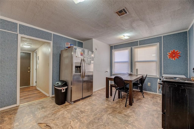 dining space featuring a textured ceiling and crown molding